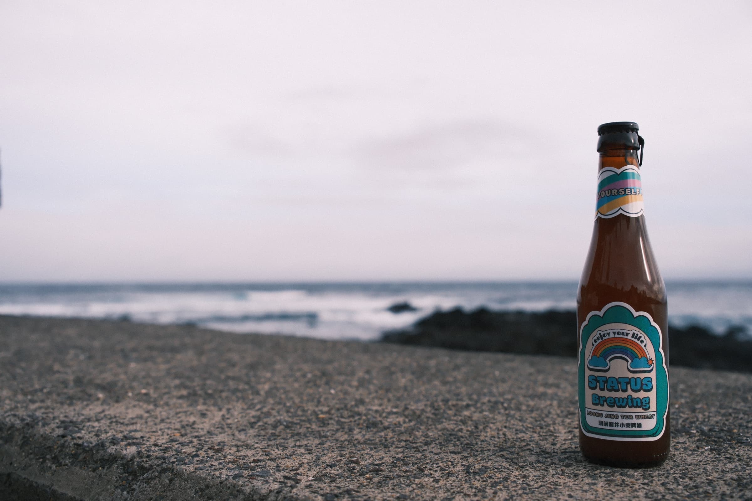 Status Brewing beer bottle by the water